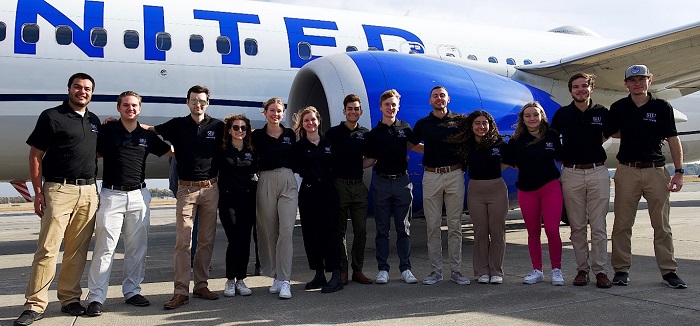 group photo of the Aviation Ambassadors in front of a plane